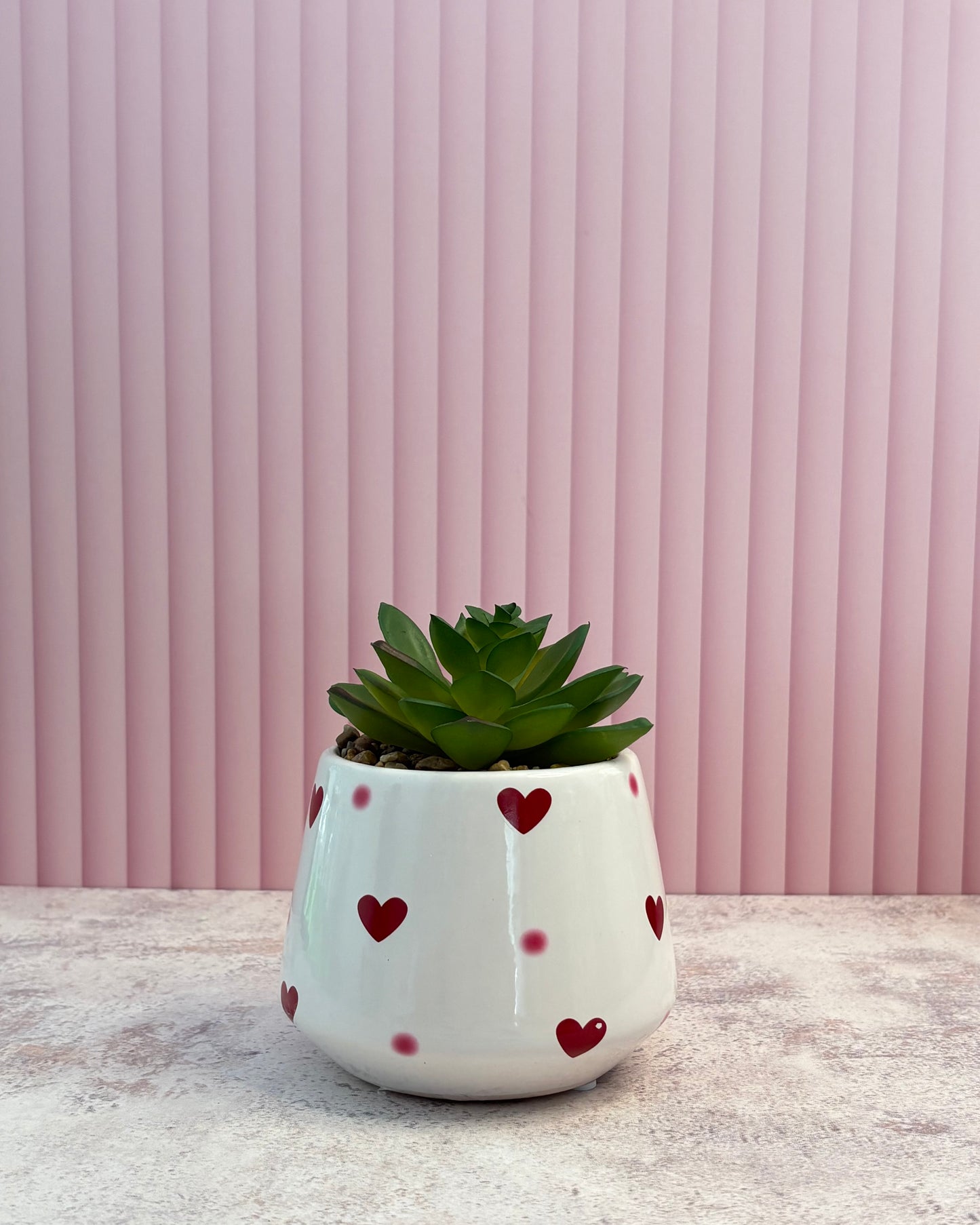Maceta de cerámica con corazones y planta artificial